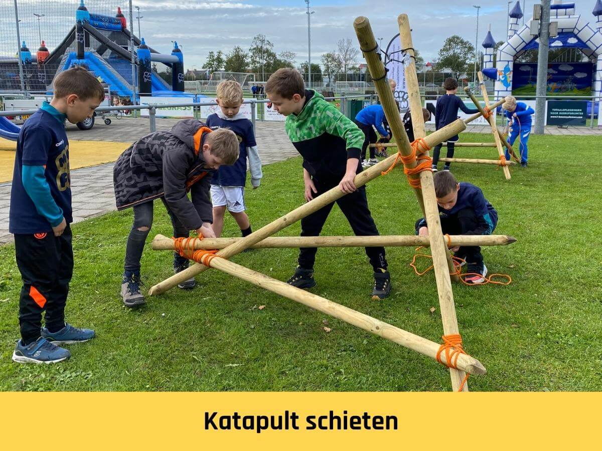 katapult bouwen en schieten Twee teams bouwen een katapult tijdens een zeskamp met kinderen