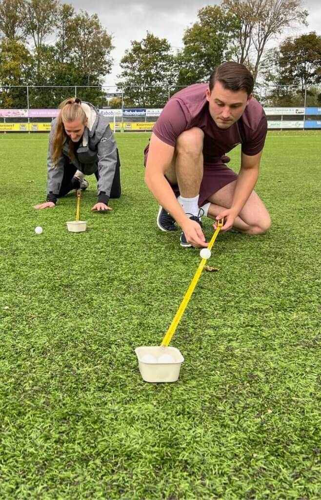 Twee deelnemers doen de bal-op-meetlat-challenge tijdens het Alleskunner teamuitje van Move For Fun.