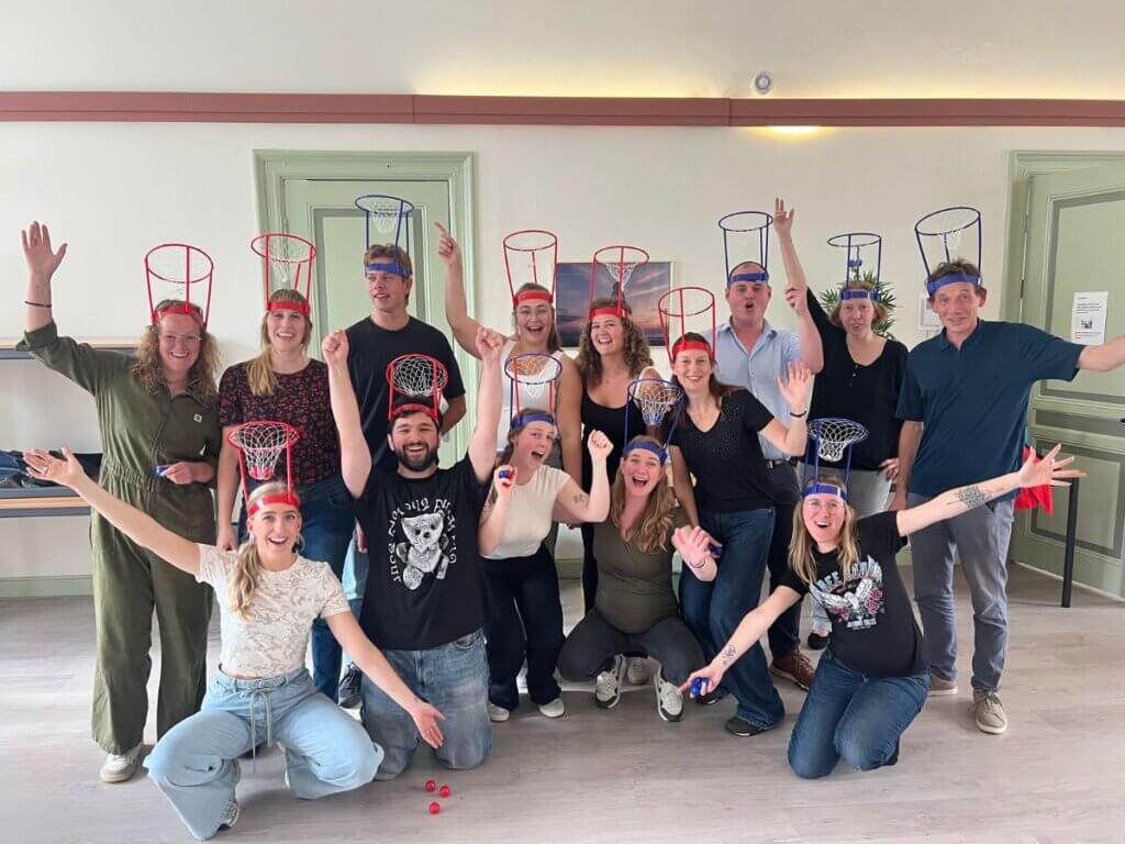 Team speelt Minute to Win It met hoofdbaskets tijdens een teamuitje van Move For Fun.