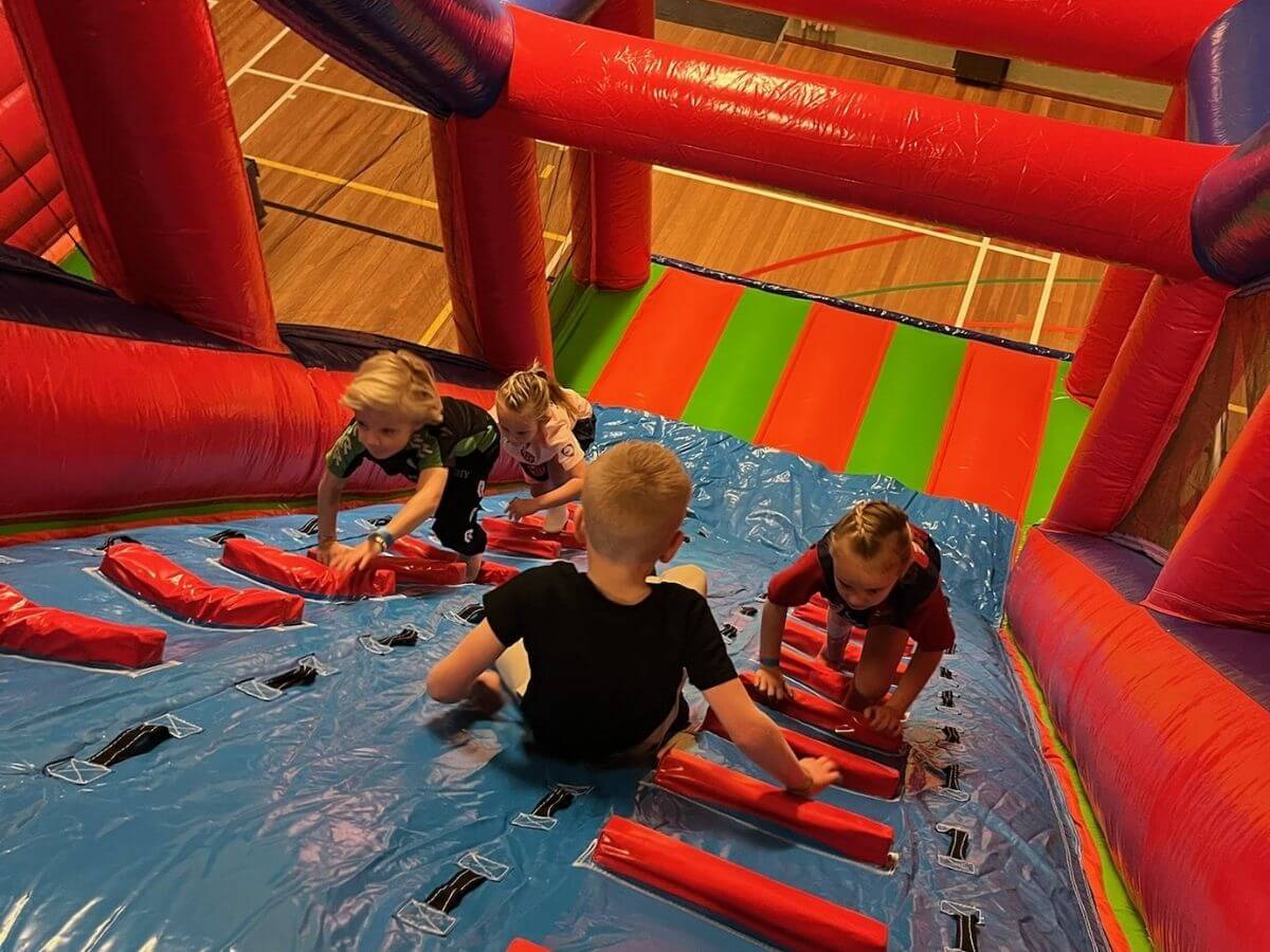 Kinderen klimmen en klauteren op een stormbaan tijdens een sport- en spelactiviteit van Move For Fun