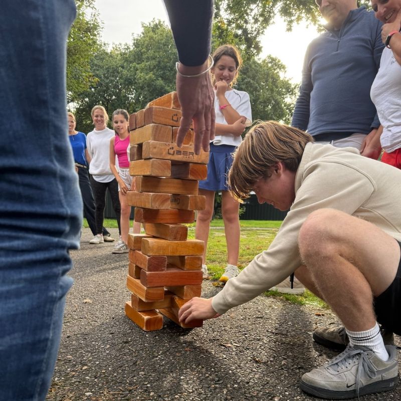 Deelnemers spelen een Jenga-opdracht tijdens het teamuitje De Alleskunner